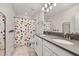 Modern bathroom featuring double vanity sinks and a shower with a whimsical fruit-themed curtain at 11354 History Ave, Orlando, FL 32832