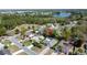 Aerial view of a community featuring homes with pools, lush greenery, and a serene lake in the background at 129 Pine Lake View Dr, Davenport, FL 33837
