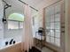 Bathroom with a tub, arched window, black fixtures, and a door leading to the outside at 129 Pine Lake View Dr, Davenport, FL 33837