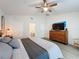 Vaulted ceiling bedroom with wood dresser, TV, ceiling fan, ensuite bath access, and wood-look floors at 129 Pine Lake View Dr, Davenport, FL 33837