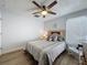 Cozy bedroom with wood floors, ceiling fan, and a comfortable bed with decorative pillows at 129 Pine Lake View Dr, Davenport, FL 33837