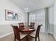 Elegant dining room with wood table, chairs, modern lighting, and natural light at 129 Pine Lake View Dr, Davenport, FL 33837