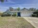 Charming single-story home with a well-maintained lawn and a bright blue front door at 129 Pine Lake View Dr, Davenport, FL 33837