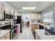 Well-lit kitchen with stainless steel appliances, light wood cabinets, and tile flooring at 129 Pine Lake View Dr, Davenport, FL 33837