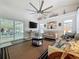 Bright living room with sliding glass doors to the patio, a large ceiling fan, and modern decor at 129 Pine Lake View Dr, Davenport, FL 33837