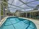 A beautiful screened-in pool, tanning deck, and covered patio with lounge area, creating a relaxing outdoor oasis at 129 Pine Lake View Dr, Davenport, FL 33837