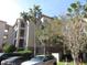 Exterior view of the building with palm trees on a sunny day at 1361 Tuscan Ter # 7406, Davenport, FL 33896