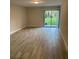 Bright living room with wood-look flooring and a sliding glass door to the outside at 145 Scottsdale Sq # 145, Winter Park, FL 32792