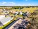 Aerial view of neighborhood homes with lush landscaping and community tennis court at 16014 Hawk Hill St, Clermont, FL 34714
