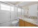Bathroom showcasing a glass-enclosed shower, toilet, and a vanity with granite countertops at 16014 Hawk Hill St, Clermont, FL 34714