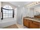 Well-lit bathroom with a soaking tub, separate glass shower, and dual vanity at 16014 Hawk Hill St, Clermont, FL 34714