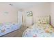 Bright bedroom featuring twin beds with playful bedding, a dresser, and a view of the outdoors at 16014 Hawk Hill St, Clermont, FL 34714