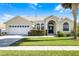 Charming single-story home with a manicured lawn, arched entry, and attached two-car garage at 16014 Hawk Hill St, Clermont, FL 34714