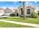 Inviting home with a well-kept lawn, arched doorway, and attached two-car garage at 16014 Hawk Hill St, Clermont, FL 34714