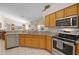 Modern kitchen with stainless steel appliances, granite countertop, and tile flooring at 16014 Hawk Hill St, Clermont, FL 34714