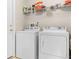 Bright laundry room featuring a modern washer and dryer with convenient shelving above at 16014 Hawk Hill St, Clermont, FL 34714
