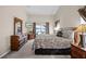 Carpeted main bedroom with pool views, television and coordinating decor at 16014 Hawk Hill St, Clermont, FL 34714