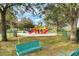Community playground with slides and play equipment surrounded by mature trees at 16014 Hawk Hill St, Clermont, FL 34714