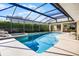 Sparkling screened-in swimming pool with jacuzzi and patio furniture, perfect for relaxation at 16014 Hawk Hill St, Clermont, FL 34714