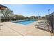 A community pool with a blue tile edge, lounge chairs, and mature trees for shade and landscaping at 16035 Wilkinson Dr, Clermont, FL 34714