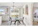 Cozy dining area with a glass table, modern lighting, and views of the backyard at 16035 Wilkinson Dr, Clermont, FL 34714