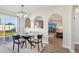 Bright dining area with a glass table, neutral decor, and archways leading to the living room at 16035 Wilkinson Dr, Clermont, FL 34714