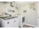 A laundry room with a washer and dryer, wire storage shelves and a sign that says, 