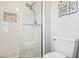 Close-up of a well-lit tiled shower with glass door and nautical wall decorations at 16035 Wilkinson Dr, Clermont, FL 34714