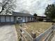 Modest single-story home with neutral exterior, simple landscaping, and a rustic wooden fence at 1756 Elbert Acres Ne Ct, Winter Haven, FL 33881
