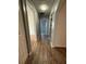 Hallway with wood look floors leading to an entry door and another room at 1756 Elbert Acres Ne Ct, Winter Haven, FL 33881