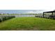 Spacious backyard with lush green grass, a fence, and a serene lake view at 1767 Smarts Rule St, Kissimmee, FL 34744