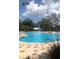 Community pool featuring a splash zone, palm trees, and a paved deck with lounge chairs at 1767 Smarts Rule St, Kissimmee, FL 34744