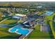 Scenic aerial view of community pool, buildings and recreation amenities surrounded by green spaces and a peaceful lake at 202 Zircon Rd, Kissimmee, FL 34758