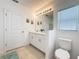 Bright bathroom featuring a double vanity, tiled floors, and decorative wall art at 202 Zircon Rd, Kissimmee, FL 34758