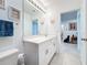 Bright bathroom with white cabinets, quartz countertop, large mirror and tile floors at 202 Zircon Rd, Kissimmee, FL 34758