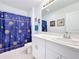 Bathroom featuring a white vanity, a large mirror, and a shower with a blue patterned curtain at 202 Zircon Rd, Kissimmee, FL 34758