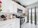 Bright kitchen with stainless steel appliances, white cabinets, and direct access to the backyard at 202 Zircon Rd, Kissimmee, FL 34758