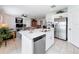 Open concept kitchen features stainless steel appliances, white cabinetry, and island with seating overlooking the living spaces at 202 Zircon Rd, Kissimmee, FL 34758
