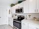 Bright kitchen featuring stainless steel appliances, white cabinets, and sleek countertops at 202 Zircon Rd, Kissimmee, FL 34758