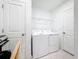 Functional laundry room with washer, dryer, wire shelving, and tiled floors at 202 Zircon Rd, Kissimmee, FL 34758