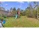 Backyard featuring a wooden playset with a slide, swing and playhouse at 2086 Blackfoot Trl, St Cloud, FL 34771