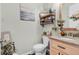 Bathroom showcasing a classic toilet, sink, and vanity, with decorative shelving at 2086 Blackfoot Trl, St Cloud, FL 34771