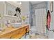This bathroom has a vessel sink on a wood vanity, a bathtub, and gray tile at 2086 Blackfoot Trl, St Cloud, FL 34771