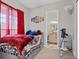 A bedroom with a telescope, red curtains, American flag art, and an ensuite bathroom at 2086 Blackfoot Trl, St Cloud, FL 34771