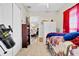View of a carpeted bedroom with a telescope, red curtains, a closet, and a view into the dining room at 2086 Blackfoot Trl, St Cloud, FL 34771