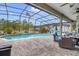 Beautiful screened pool with waterfall feature, patio furniture, and mature landscaping at 2086 Blackfoot Trl, St Cloud, FL 34771