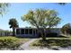 Charming single-story home with a screened-in porch, lush lawn, and mature trees at 2326 S Peninsula Dr, Daytona Beach, FL 32118