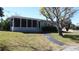 Charming single-story home featuring a screened porch and well-maintained lawn with mature trees at 2326 S Peninsula Dr, Daytona Beach, FL 32118
