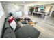Open living area with a spacious gray sectional sofa, modern decor, and access to the dining area and recreation room at 2326 S Peninsula Dr, Daytona Beach, FL 32118