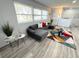 Bright living room featuring a comfortable gray sectional sofa, modern rug, and lots of natural light from a large window at 2326 S Peninsula Dr, Daytona Beach, FL 32118